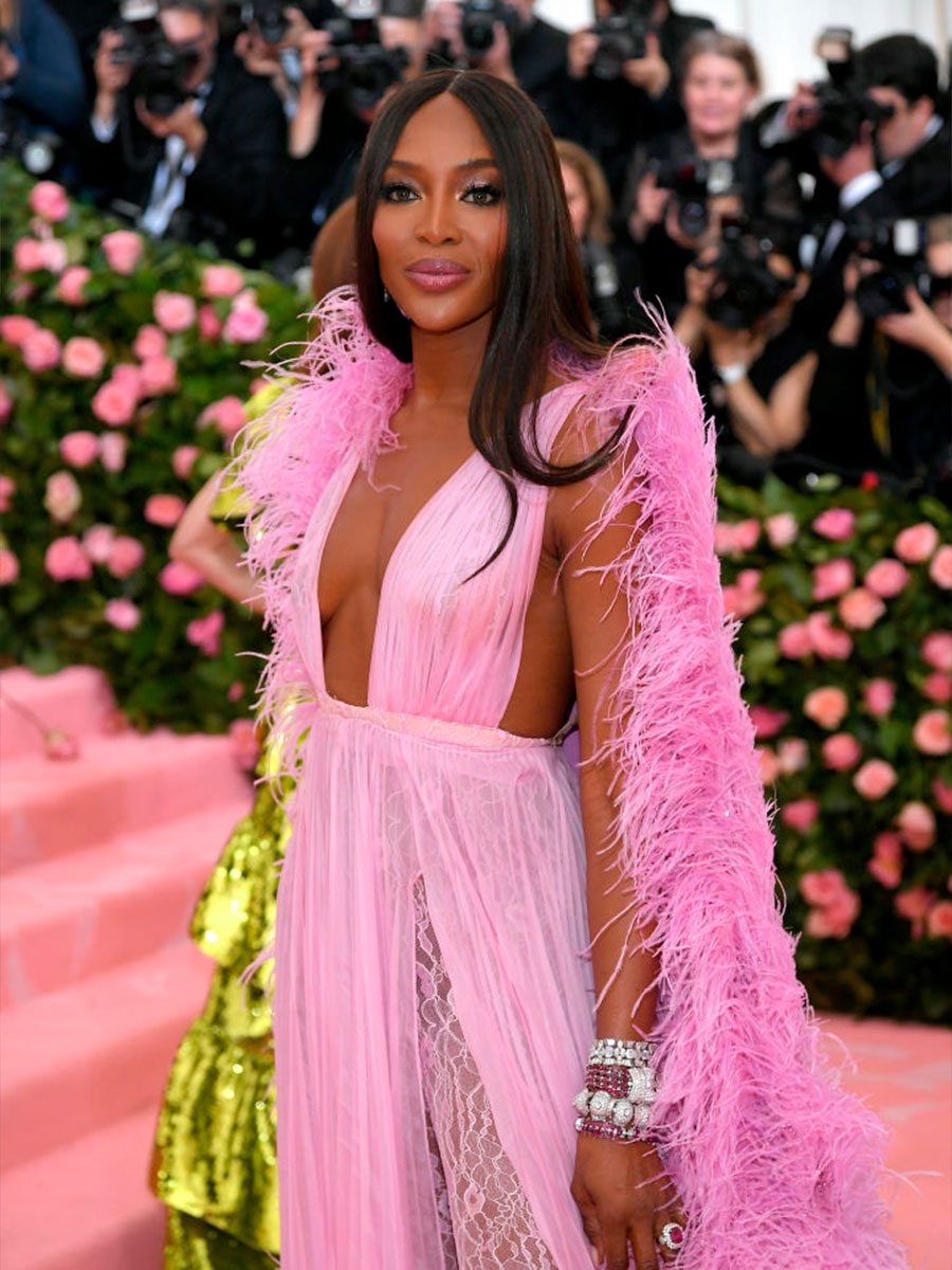 Naomi Campbell indossa un abito rosa con pelliccia sulle spalle