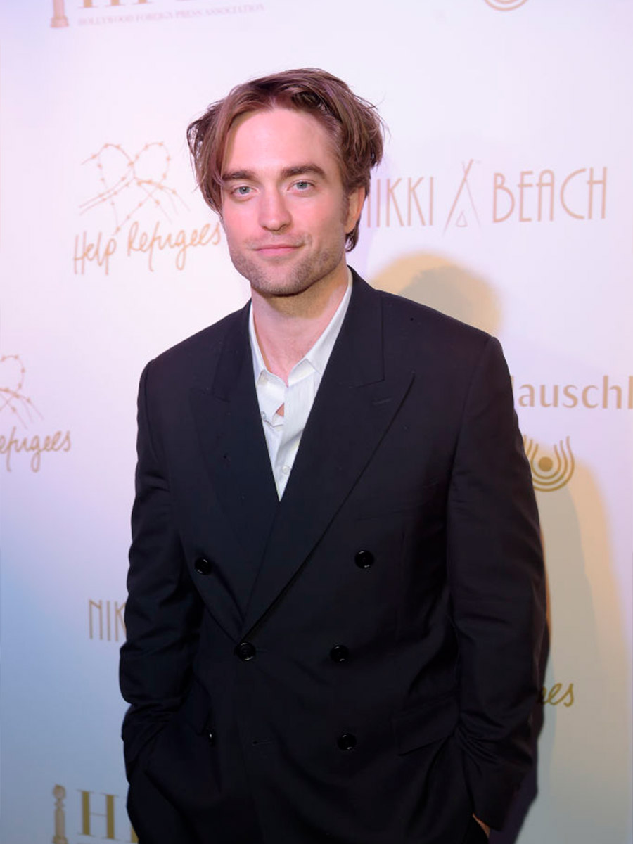 Robert Pattinson sorridente con una giacca scura