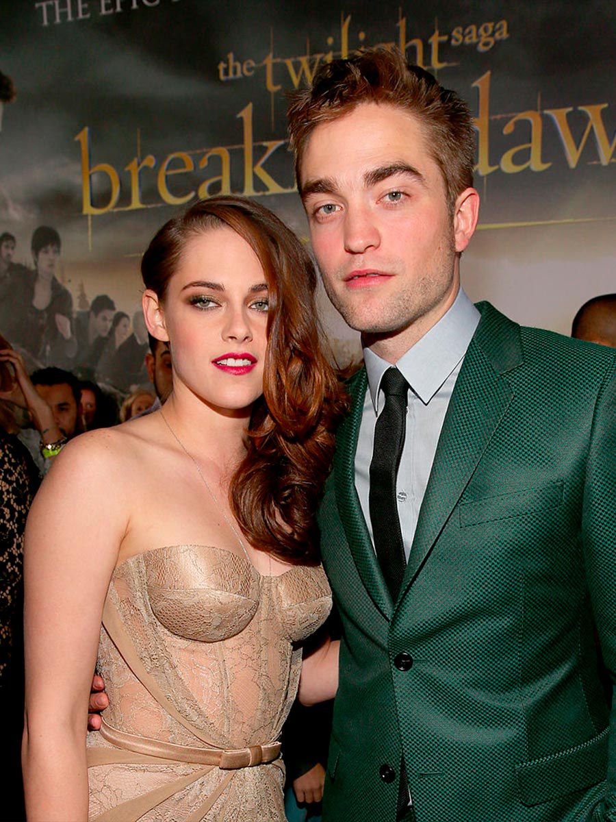 Robert Pattinson in giacca verde vicino a Kristen Stewart