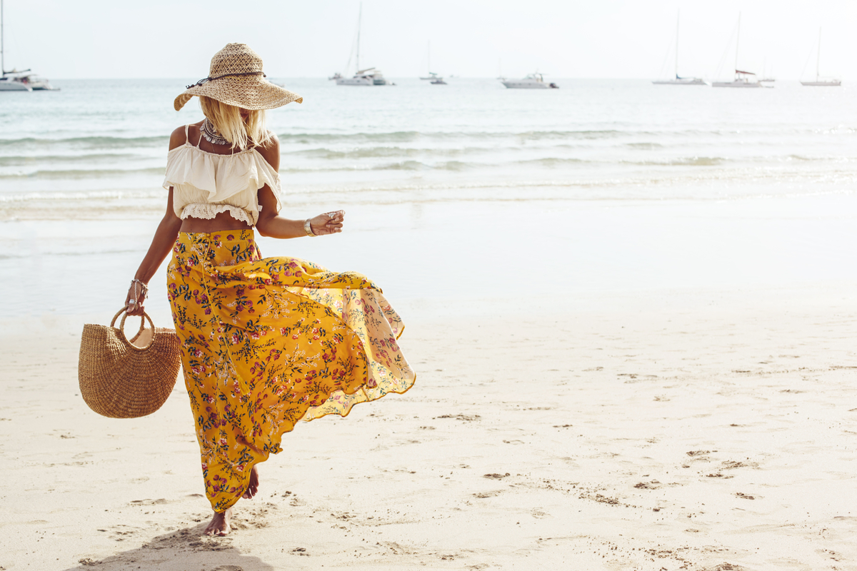 Donna al mare con una borsa di paglia