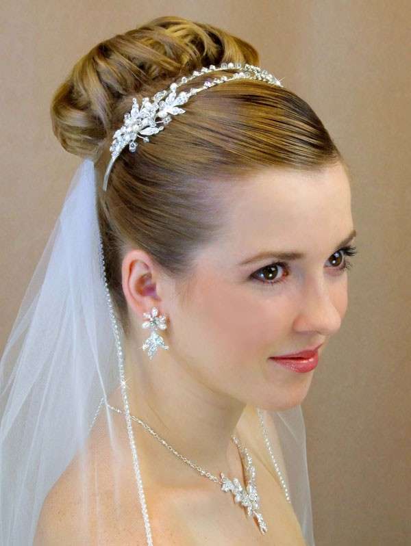 Capelli sposa con chignon alto e cristalli