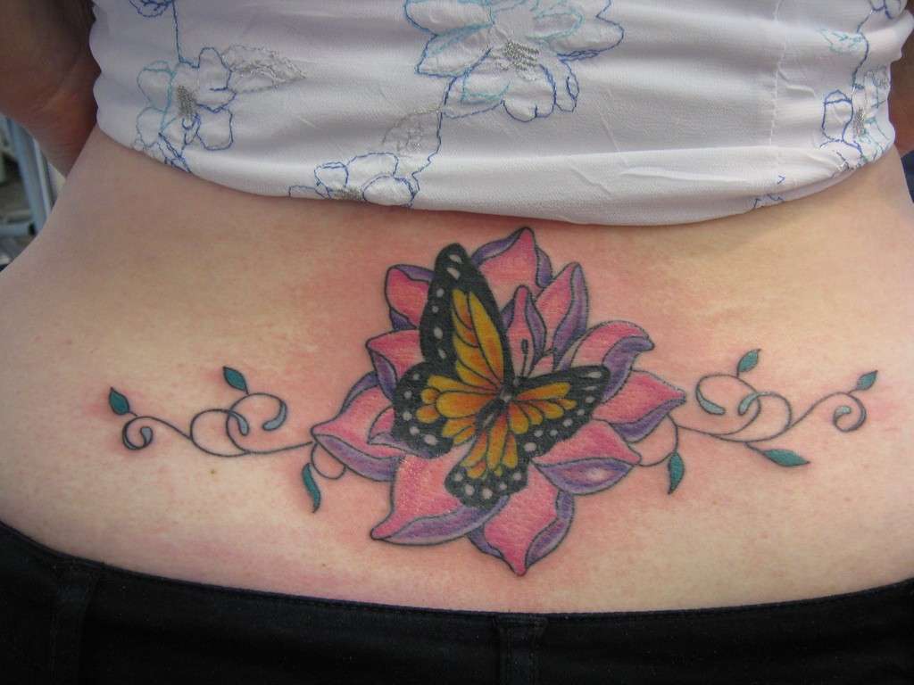 Tatuaggi lombari colorati: fiore e farfalla