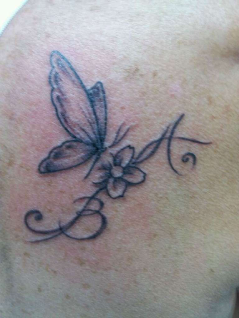 Tatuaggio con farfalla, fiore e lettere iniziali