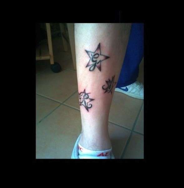 Tatuaggio sul polpaccio con lettere dentro stelle
