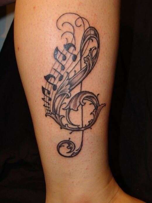 Tatuaggio chiave di violino e note in stile tribale