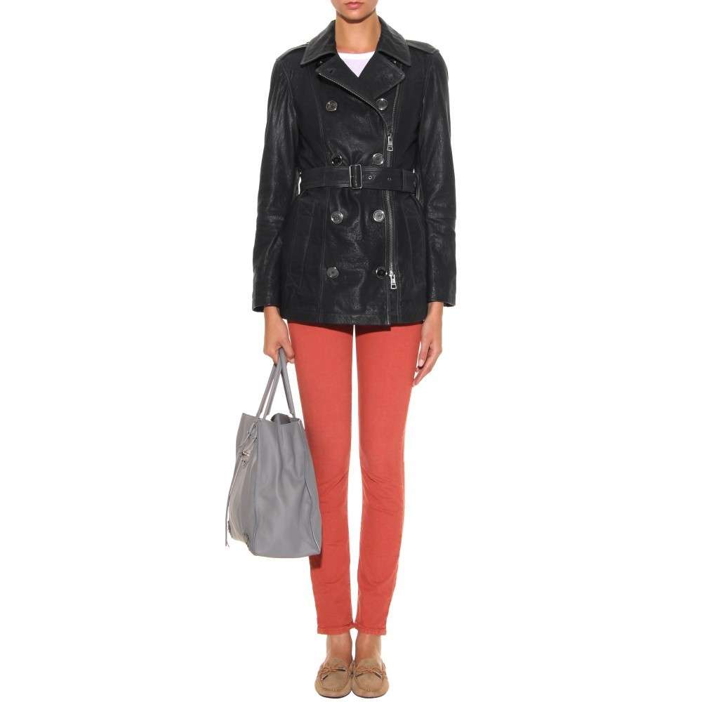 Leggings arancio abbinati a giacca in pelle nera