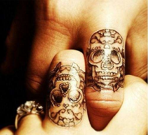 Teschi sulle dita per il tatuaggio in due