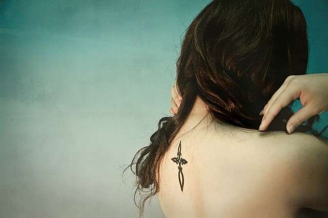 Croce tribale tatuata sulla schiena