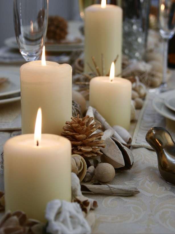 Decorazioni con candele, pigne e frutta secca