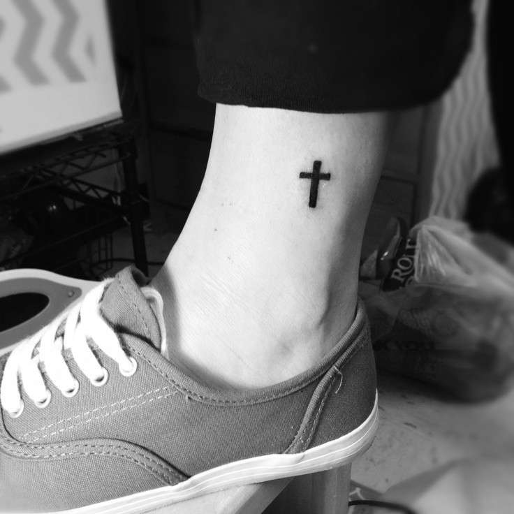 Piccola croce tatuata sulla caviglia