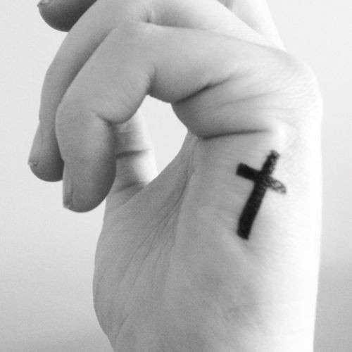 Piccolo tatuaggio sulla mano a forma di croce