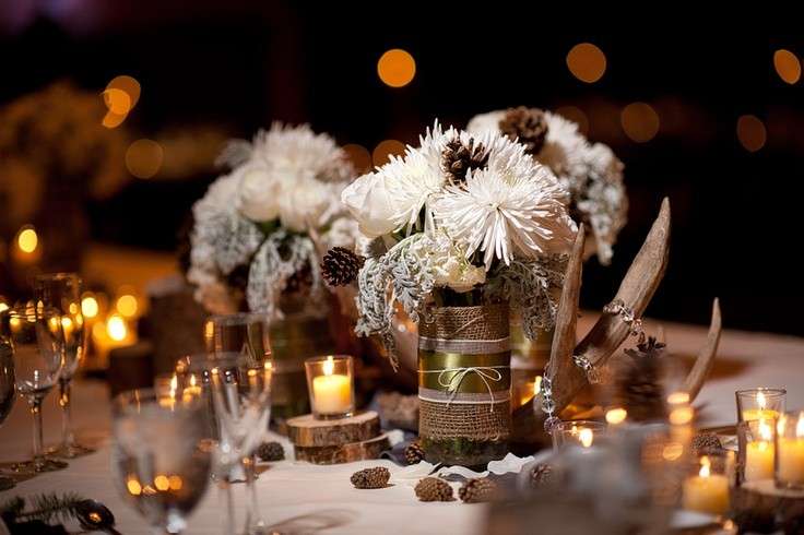Tavola con pigne, fiori bianchi e candele