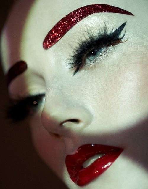 Labbra rosse e glitter sulle sopracciglia