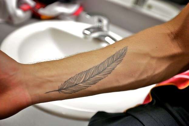 Tatuaggio con piuma su braccio