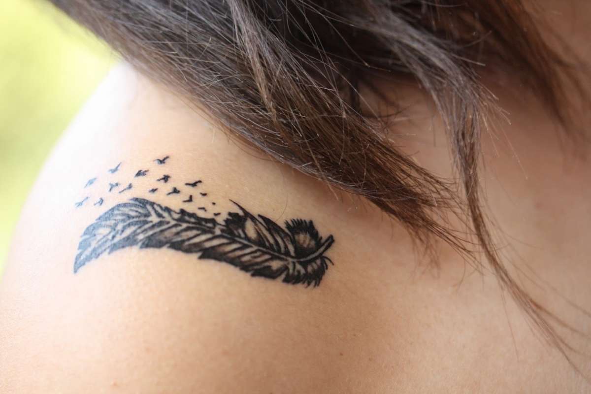 Tatuaggio con piuma su spalla