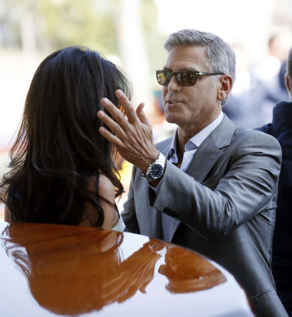 Clooney accarezza i capelli di Amal