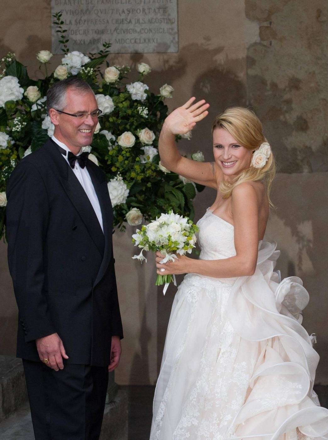 Michelle Hunziker in abito bianco con il bouquet