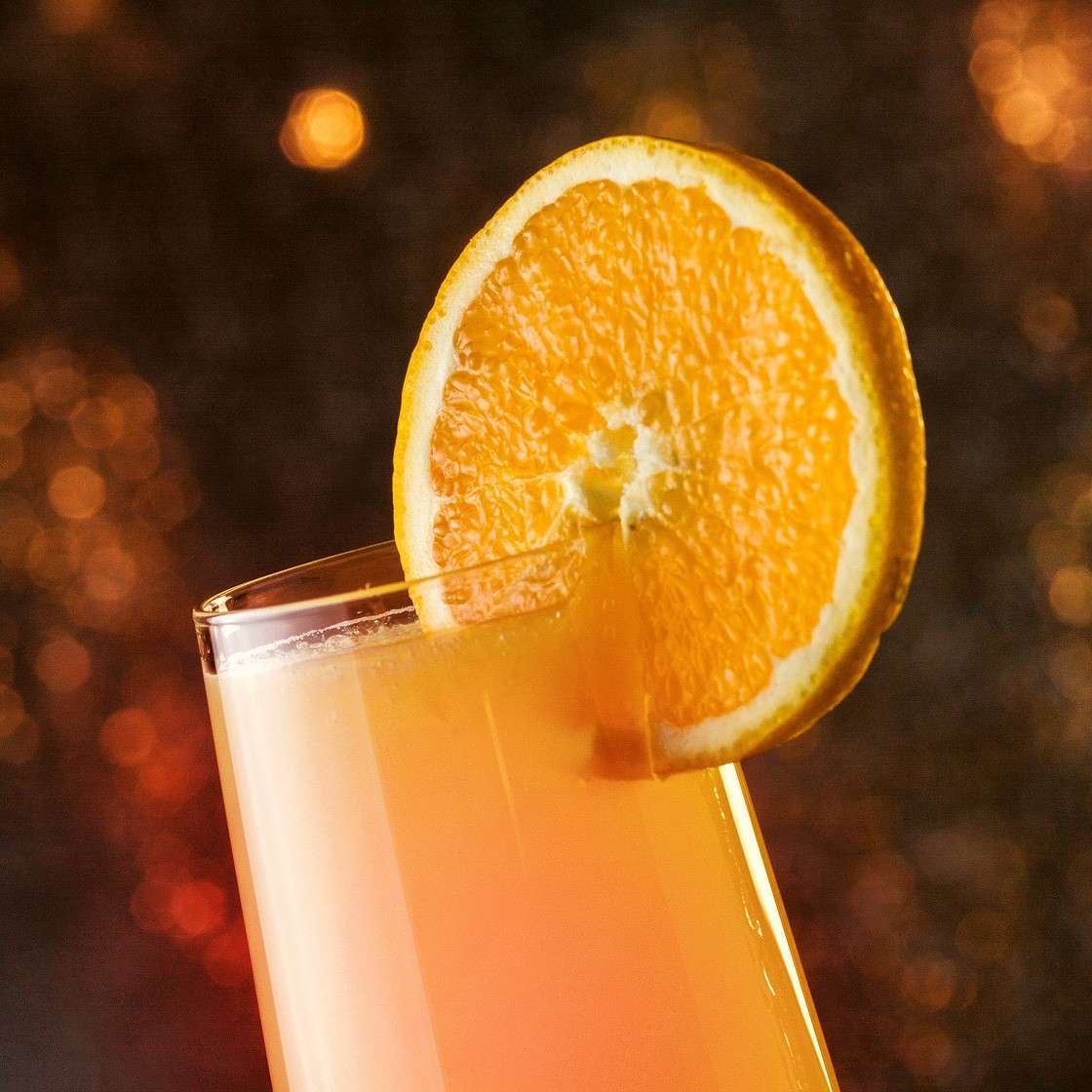 Cocktail mimosa servito con fetta di arancia