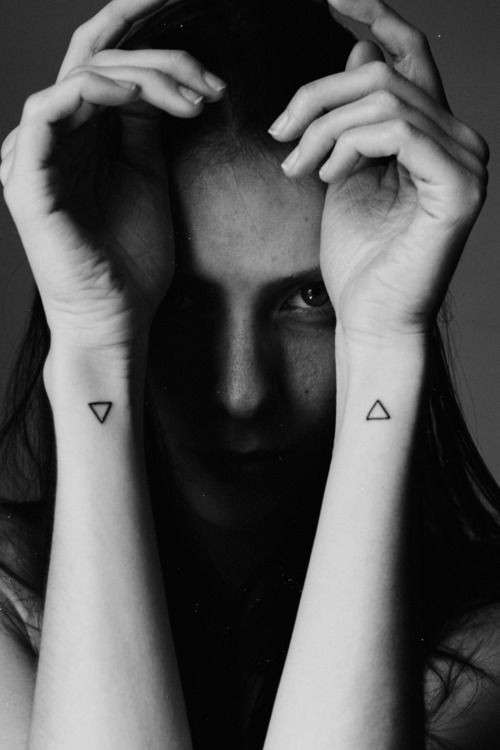 Tatuaggio minimal con doppio triangolo sui polsi