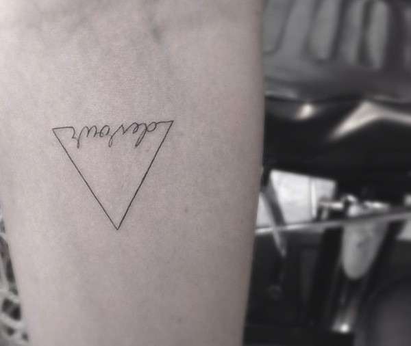 Tatuaggio minimal con triangolo e scritta