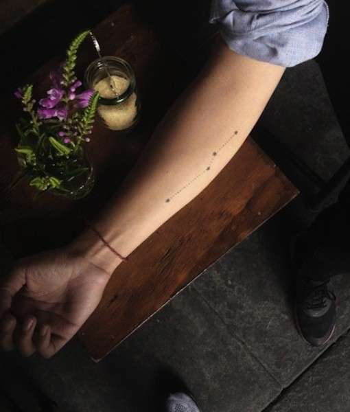 Tatuaggio minimal sul braccio con costellazione