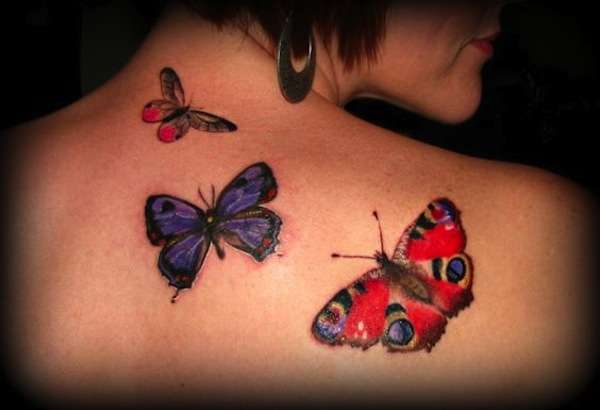 Tatuaggio farfalle colorate sulla schiena in blu e rosso