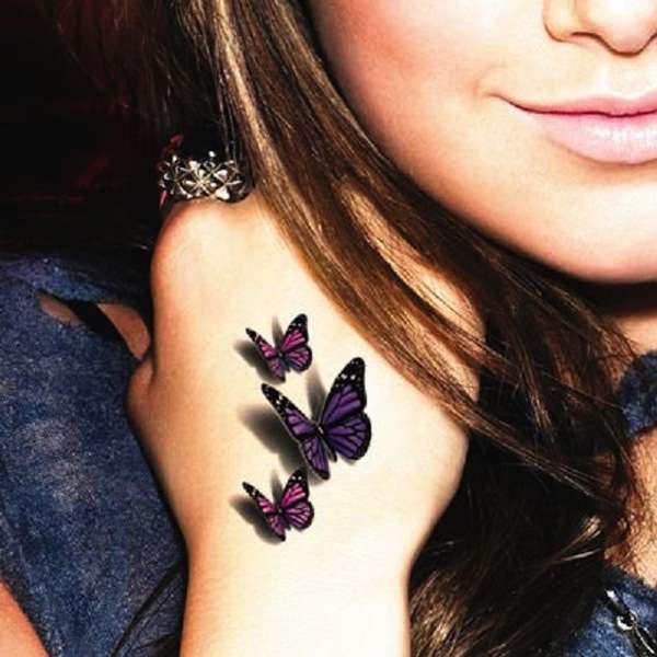 Tatuaggio tre farfalle colorate 3D sulla mano