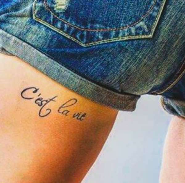 Tatuaggio C'est la vie sulla coscia