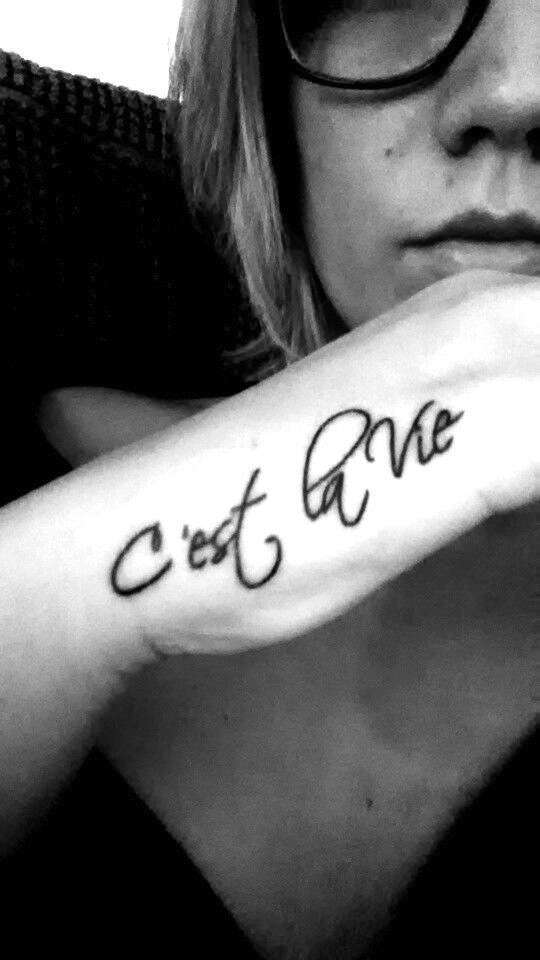 Tatuaggio con frase francese C'est la vie sulla mano