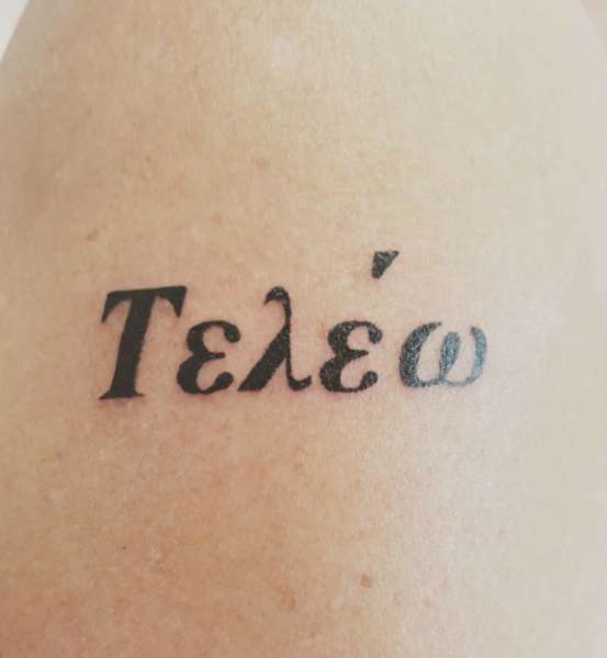 Tatuaggio con verbo greco Compiere