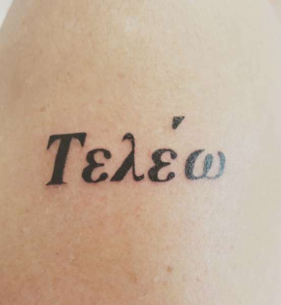 Tatuaggio con verbo greco Compiere