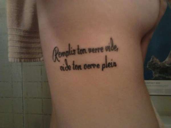 Tatuaggio frase francese sul fianco