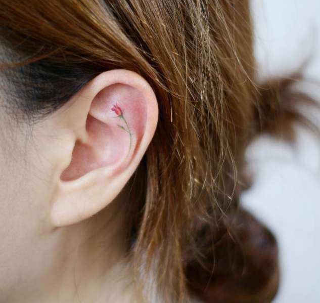 Tatuaggio con piccola rosa rossa nell'orecchio