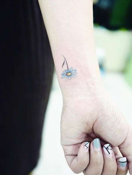 Tatuaggio con margherita colorata azzurra