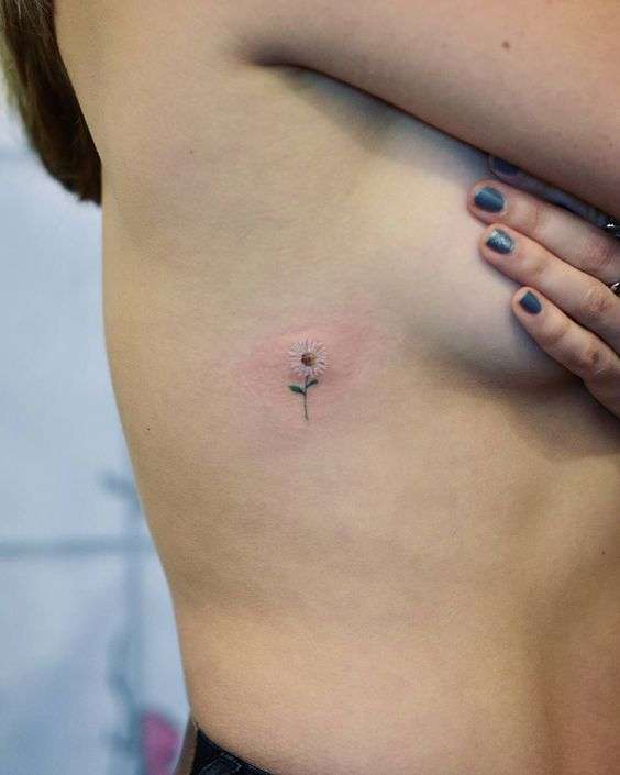 Tatuaggio con margherita piccola sotto il seno