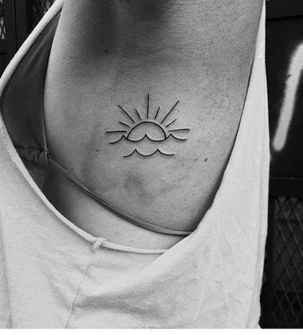 Tatuaggio stilizzato del sole sul mare