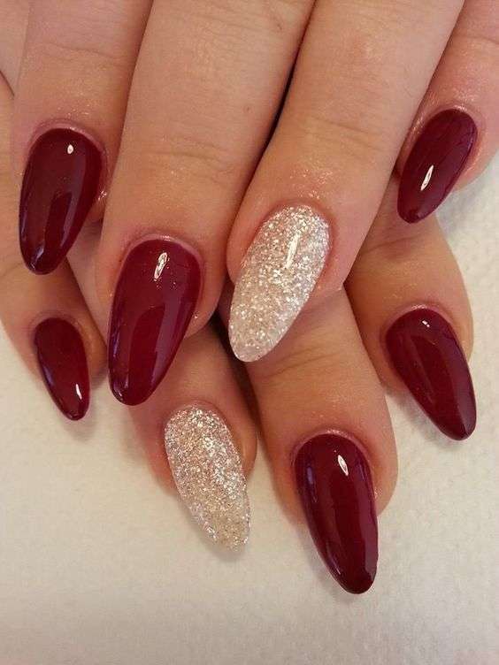 Unghie natalizie glitterate oro con smalto rosso