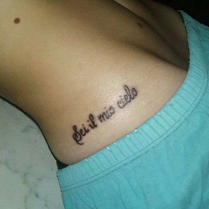 Tatuaggio sul fianco con frase di Tiziano Ferro