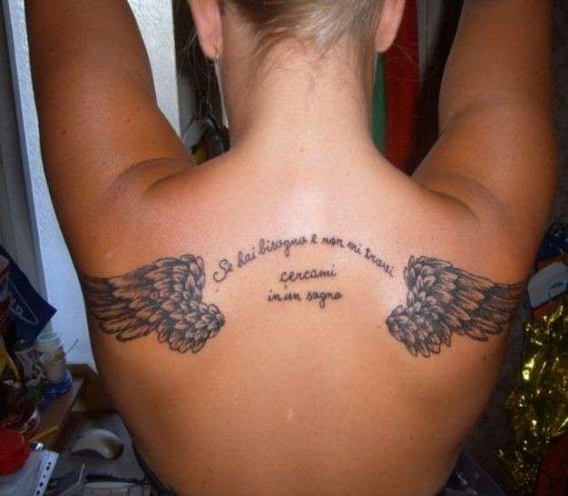 Tatuaggio schiena con ali d'angelo e frase di Vasco
