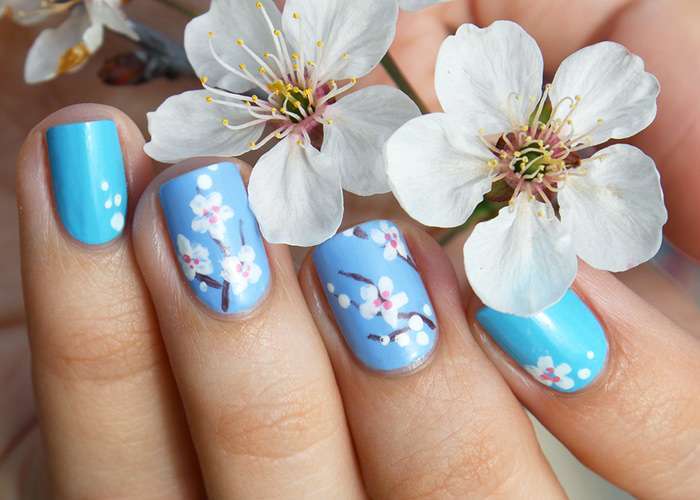 Unghie azzurre con nail art a fiori