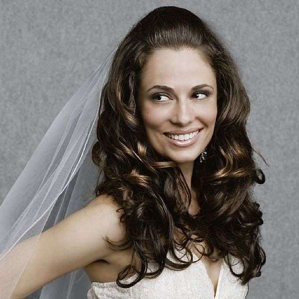 Capelli ricci e lunghi semiraccolti per una sposa