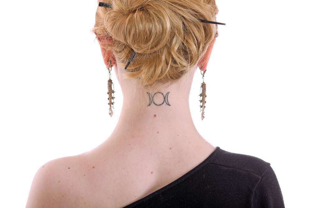 Piccolo tatuaggio femminile dietro il collo
